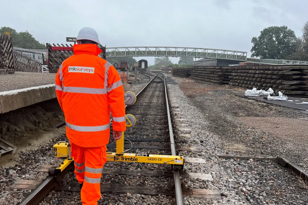 Man in high vis jacket scanning railway track